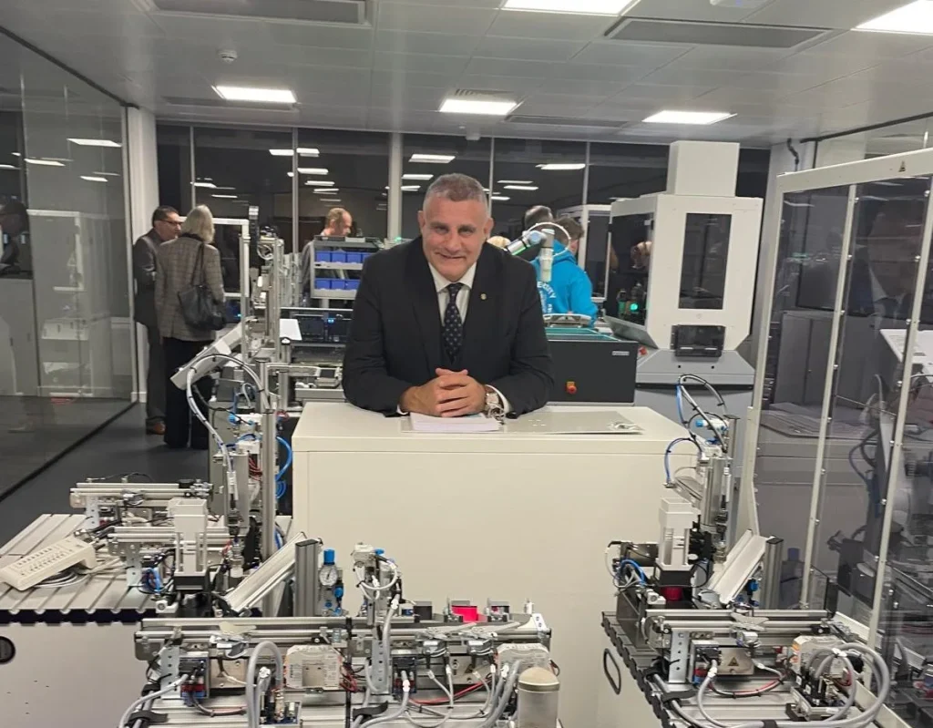 Paul Cadman in an engineering training lab with automated production equipment