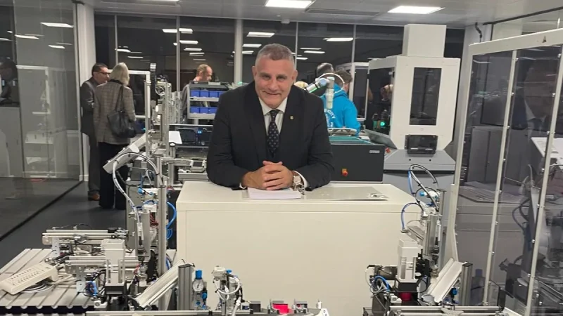 Paul Cadman in an engineering training lab with automated production equipment