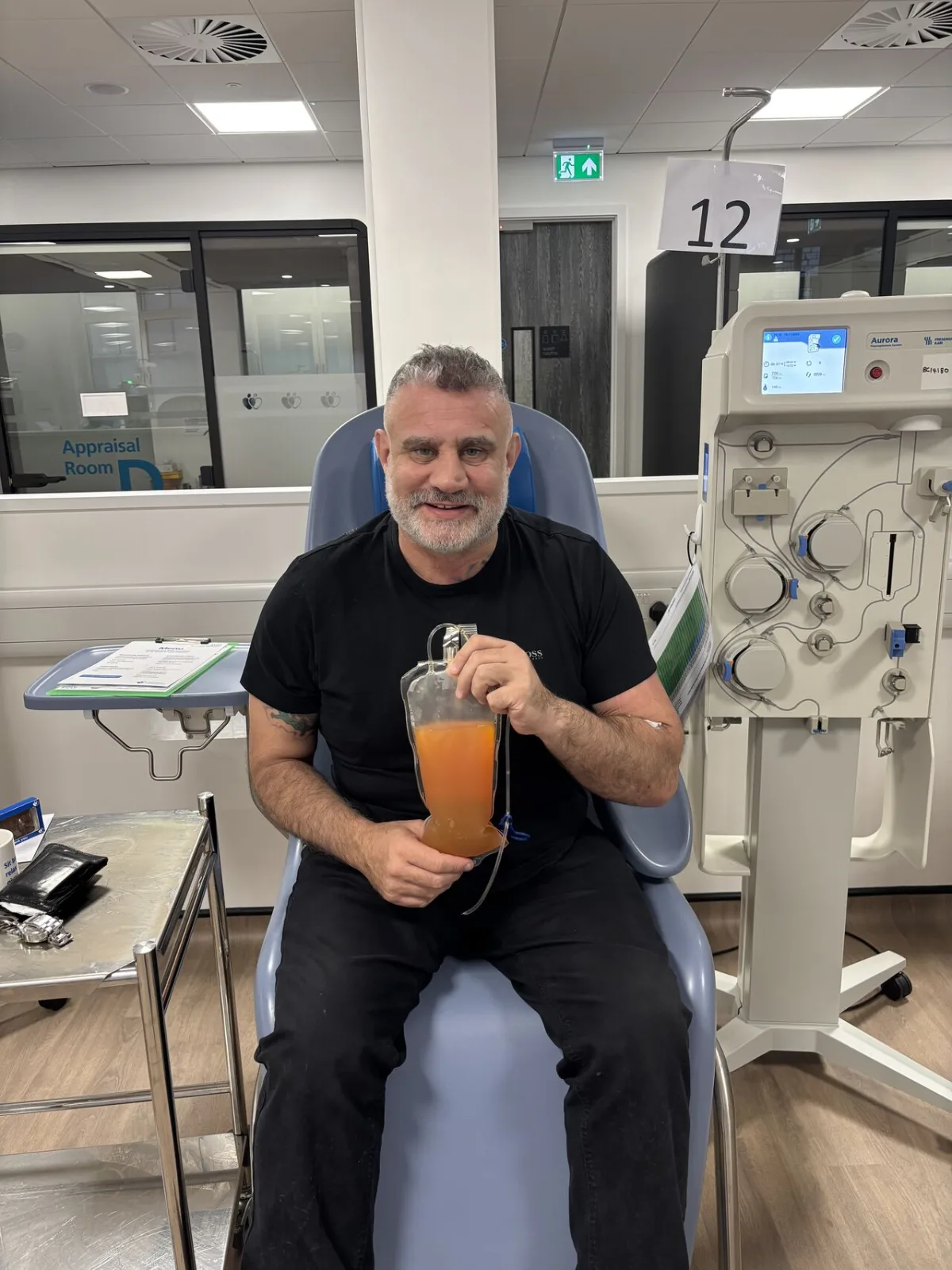 Paul Cadman holding a bag of donated plasma at a donor centre