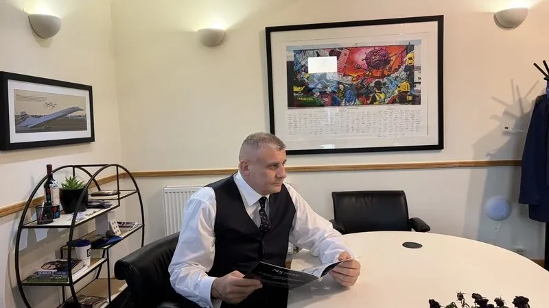 Paul Cadman seated at a meeting table in an office