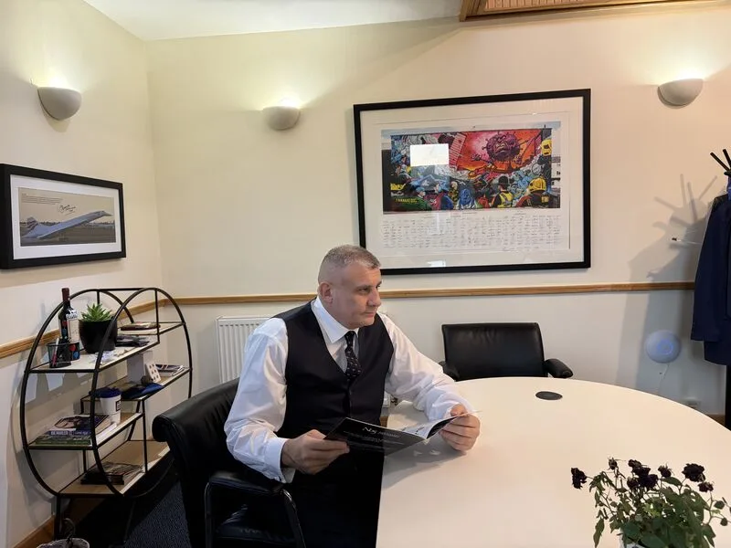 Paul Cadman seated at a meeting table in an office